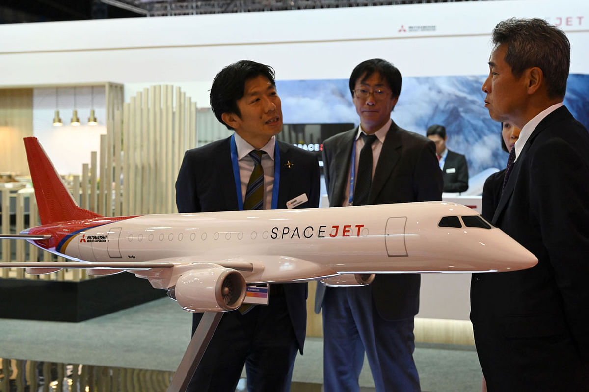 This picture taken on 13 February 2020 shows exhibtors standing next to the Spacejet model display at the Mitsubishi Aircraft Corporation booth during the Singapore Airshow in Singapore. Photo: AFP