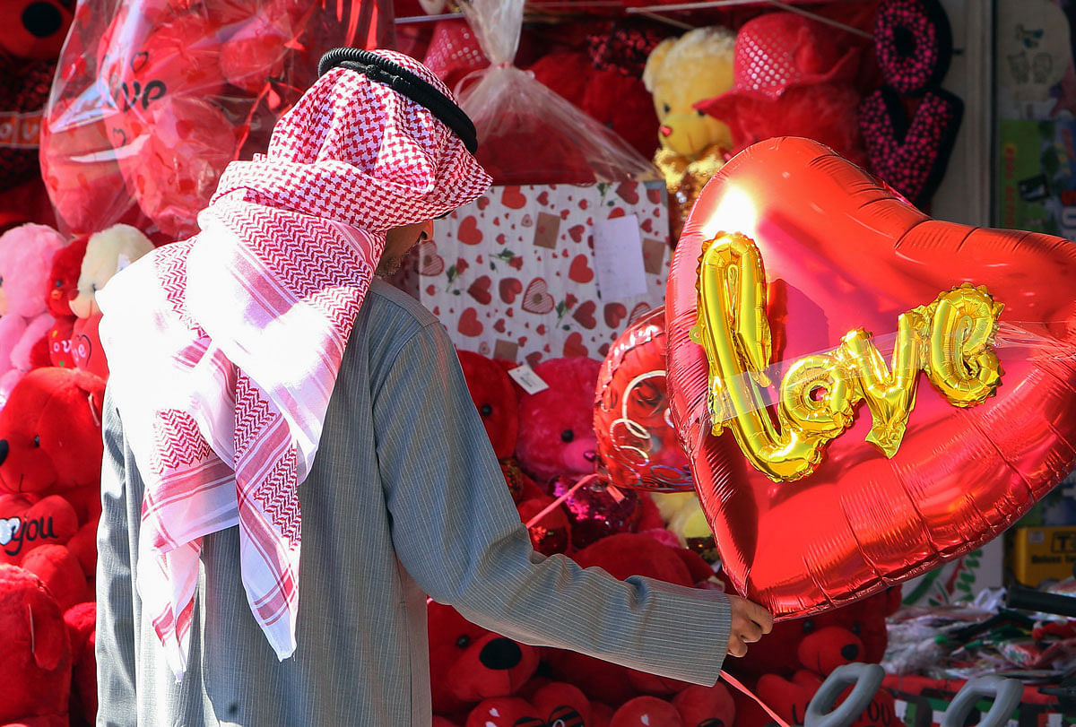 A Kuwaiti man holds a heart-shaped balloon on display outside a shop in Kuwait City ahead of Valentine`s day. Photo: AFP