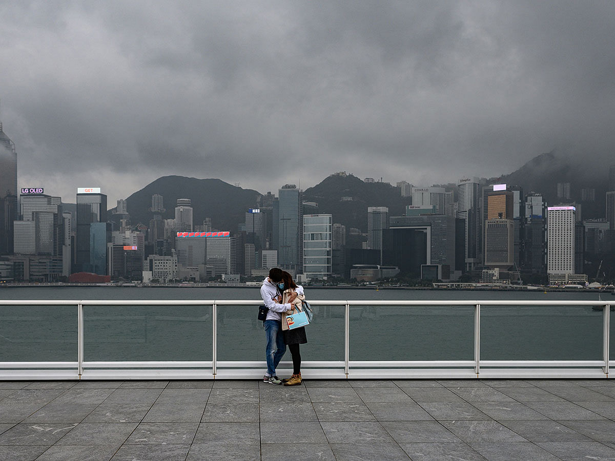 A couple wears face masks as a preventative measure against the COVID-19 coronavirus, as they stand at the hug at the observation deck in Tsim Sha Tsui of Hong Kong on 14 February 2020. Photo: AFP