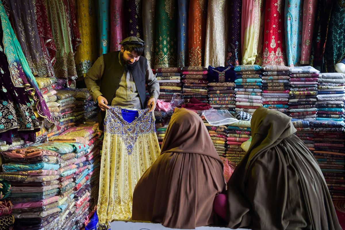 In this picture taken on 12 February 2020, Afghan refugee women shop for clothing in a store in a bazaar at a neighbourhood locally known as `mini Kabul` in Peshawar. Photo: AFP