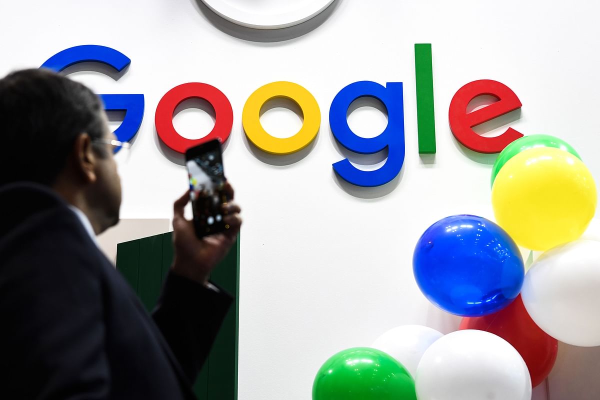 A man takes a picture with his mobile phone of the logo of the US multinational technology and Internet-related services company Google as he visits the Vivatech startups and innovation fair, in Paris. Photo: AFP