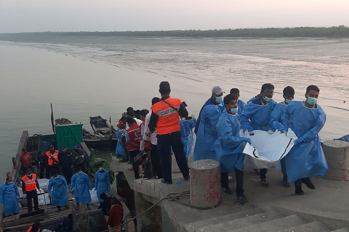 Rescue workers carry a dead body (R) following a boat capsizing accident, in Teknaf on 11 February 2020. At least 15 people drowned and dozens are unaccounted for after a boat carrying Rohingya refugees sank off southern Bangladesh early on 11 February, officials said. Photo: AFP