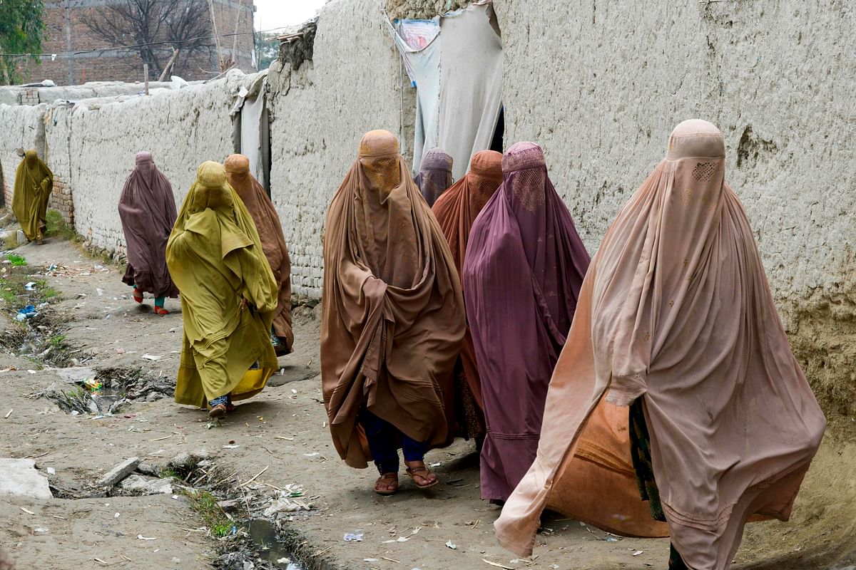 In this picture taken on 12 February 2020, Afghan refugee women walk in a refugee camp in Peshawar. Photo: AFP