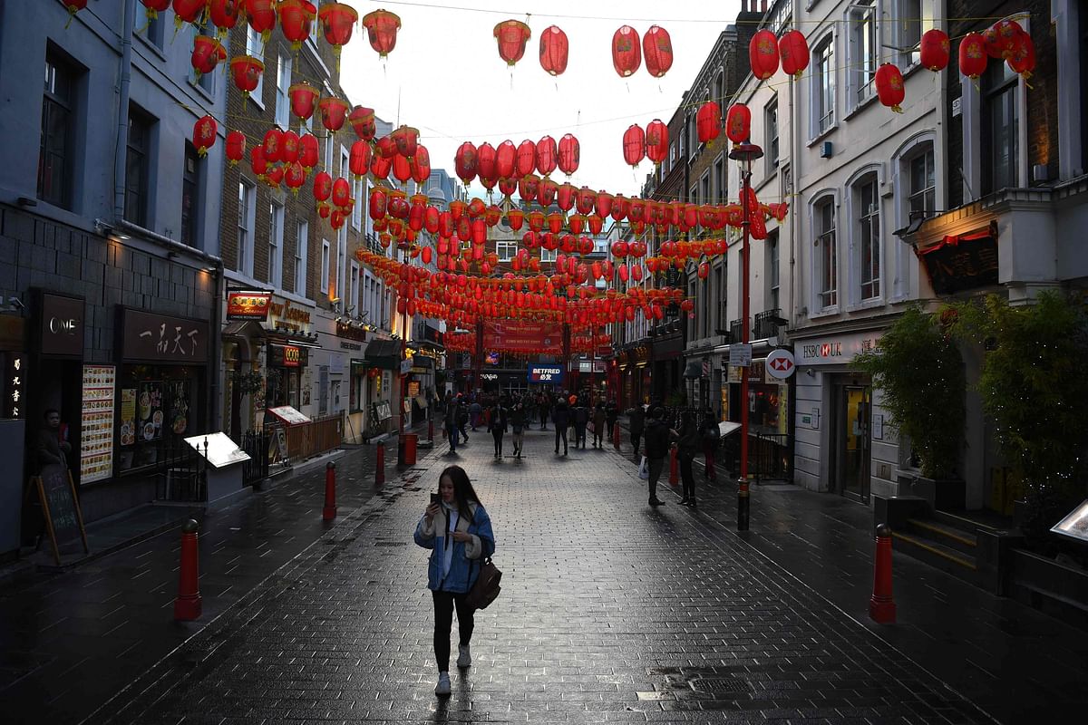 This file photo taken on 13 February 2020 shows visitors walking under Lunar New Year decorations in London`s Chinatown district. Photo: AFP
