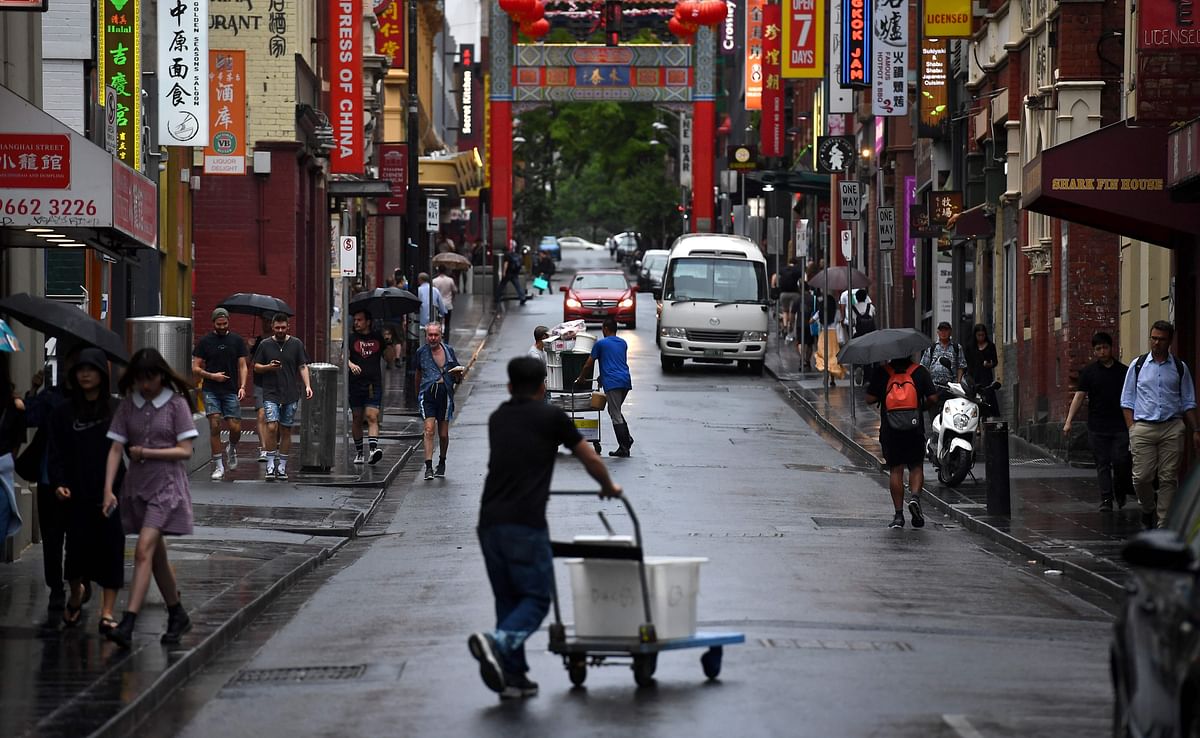 This photo taken on 14 February 2020 shows people walking along a street in Melbourne`s Chinatown. Bustling century-old Chinatowns from Melbourne to San Fransisco have fallen quiet and businesses are struggling to survive as fears over the deadly novel coronavirus outbreak ripple around the world. Photo: AFP