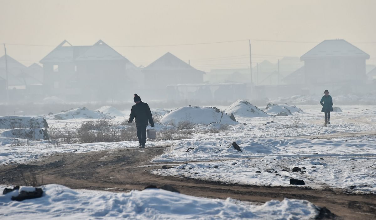 Youths walk amid smog on the outskirts of the Kyrgyz capital of Bishkek on 29 January 2020. photo: AFP
