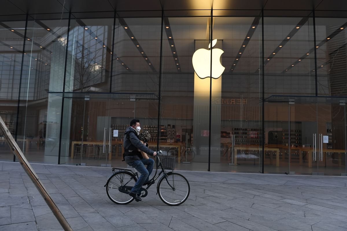 In this file photo taken on 8 February, 2020 a man cycles past a closed Apple store in Beijing. Photo: AFP