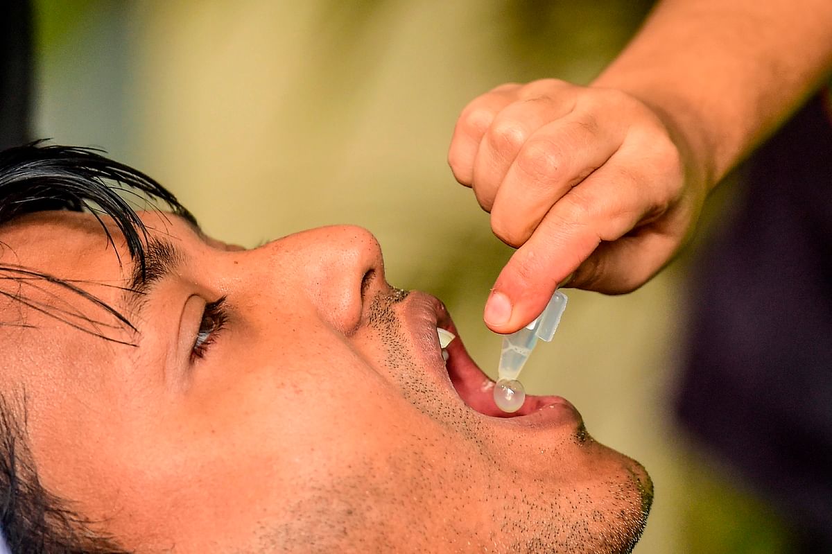 A man receives an oral cholera vaccine from a health worker during a vaccination campaign in Dhaka on 19 February 2020. Photo: AFP