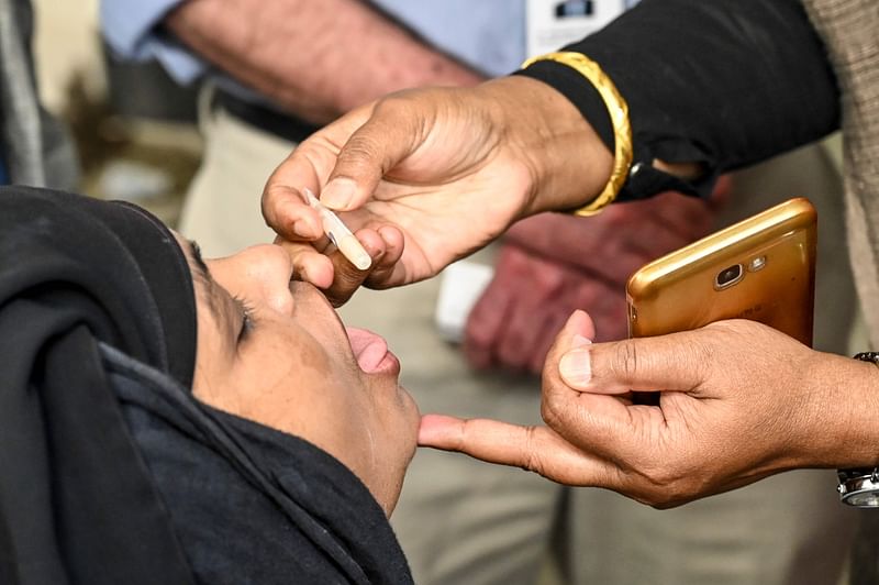 A woman receives an oral cholera vaccine from a health worker during a vaccination campaign in Dhaka on 19 February 2020. Photo: AFP