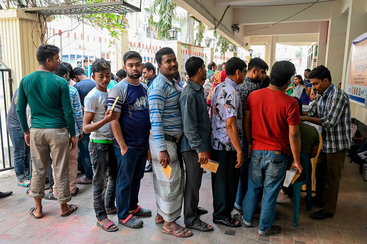 People queue waiting to receive oral cholera vaccines from health workers during a vaccination campaign in Dhaka on 19 February 2020. Photo: AFP