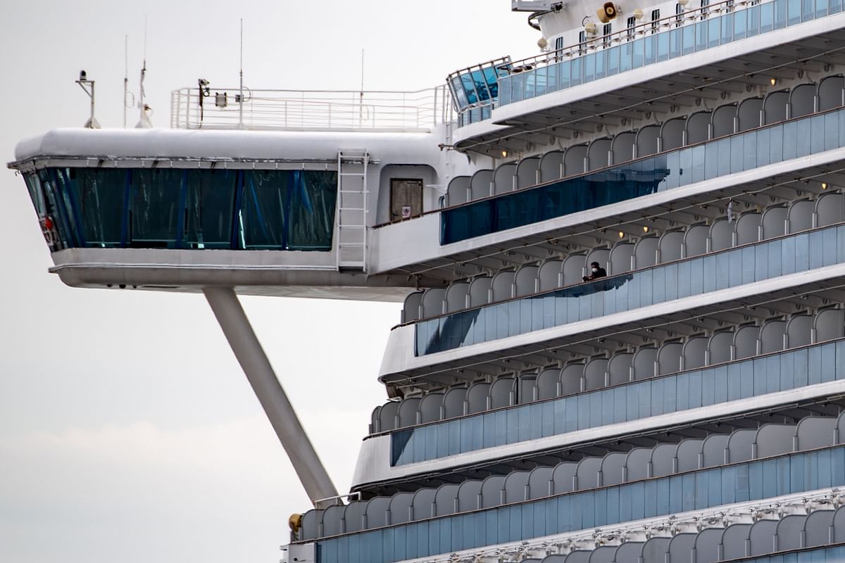 A passenger wearing a face mask looks out from the cabin of the Diamond Princess cruise ship, in quarantine due to fears of new COVID-19 coronavirus, at Daikoku pier cruise terminal in Yokohama on 20 February 2020. Photo: AFP