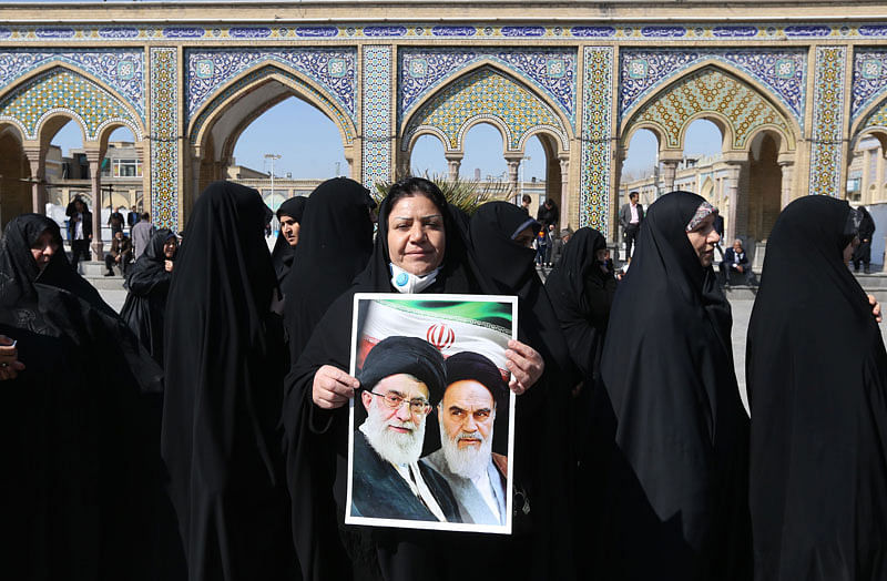 Iranians hold portraits of former and current Supreme Leaders, Ayatollah Ruhollah Khomeini and Ayatollah Ali Khamenei, as they queue up to vote during parliamentary elections at the Shah Abdul Azim shrine on the southern outskirts of Tehran on 21 February, 2020. Photo: AFP