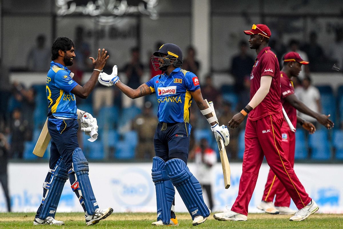 Sri Lanka`s Wanindu Hasaranga (C) and Nuwan Pradeep (L) celebrate after Sri Lanka won by 1 wicket during the first one day international (ODI) cricket match between Sri Lanka and West Indies at the Sinhalese Sports Club (SSC) International Cricket Stadium in Colombo on 22 February, 2020. Photo: AFP