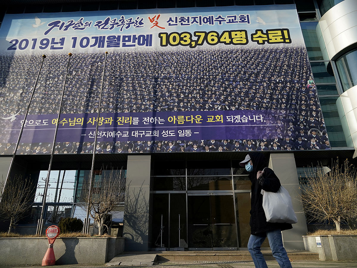 A man wearing a mask to prevent contracting the coronavirus walks past a branch of the Shincheonji Church of Jesus the Temple of the Tabernacle of the Testimony in Daegu, South Korea on 21 February 2020. Reuters File Photo