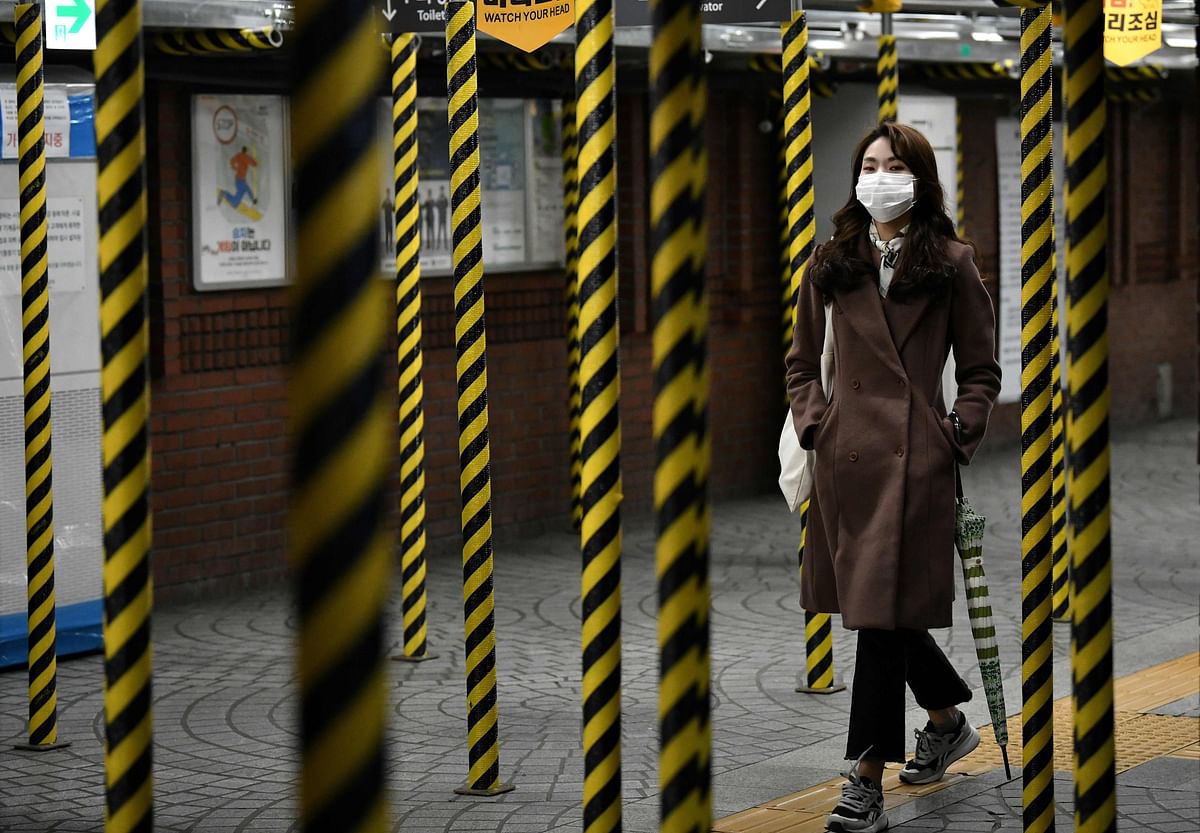 A woman wearing a face mask walks between columns at a subway station being renovated in Seoul on 22 February 2020. Photo: AFP