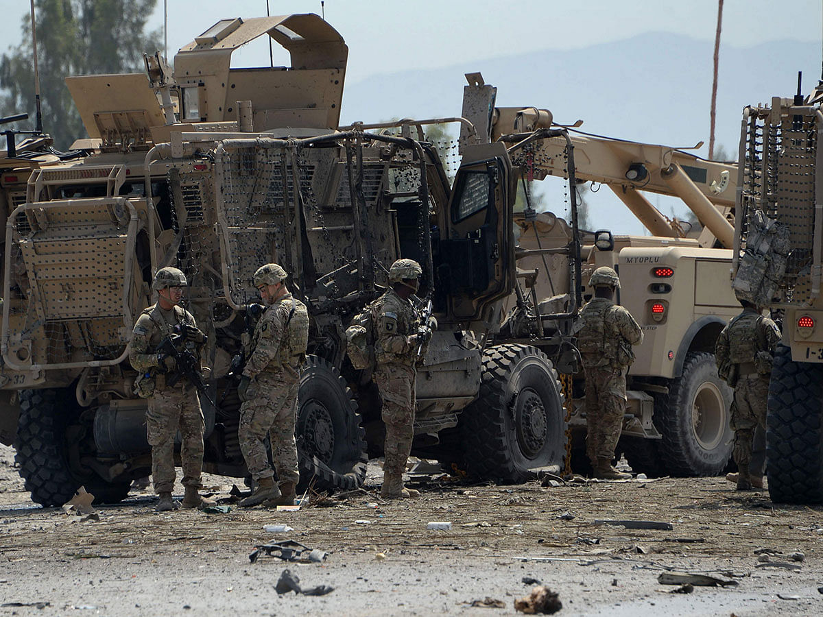 In this file photo taken on 10 April 2015 US soldiers inspect the scene of a suicide bomb attack near the airport in the Afghan city of Jalalabad. Photo: AFP