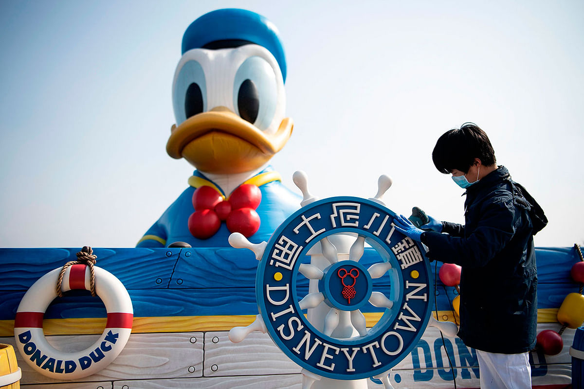 A worker wearing a protective facemask polishes a helm at the temporarily closed Shanghai Disney resort in Shanghai on 23 February 2020. Photo: AFP