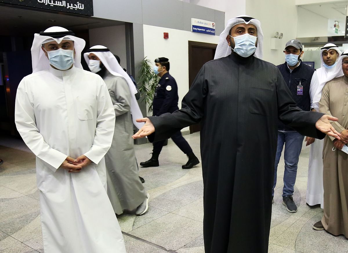 Kuwaiti health minister Sheikh Basel al-Sabah (R) speaks to the press at Sheikh Saad Airport in Kuwait City, on 22 February, as Kuwaitis returning from Iran wait before being taken to a hospital to be tested for coronavirus. Photo: AFP