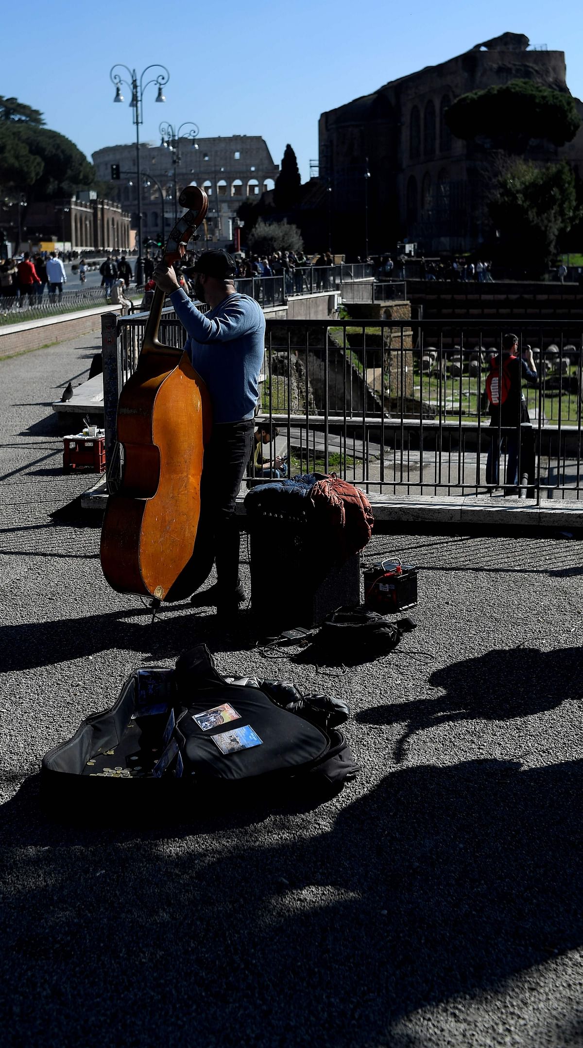A street musician plays a double bass by the ancient Roman Forum in Rome on 21 February 2020 within the presentation of an ancient tomb thought to belong to Rome`s founder Romulus, discovered under the Forum in the heart of Italy`s capital decades ago. Photo: AFP