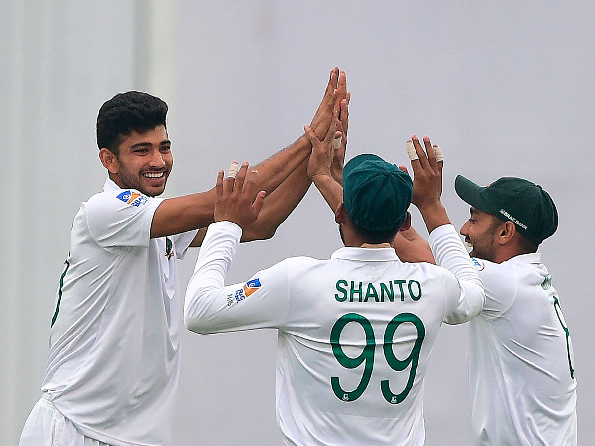 Bangladesh`s Nayeem Hasan (L) celebrates with teammates after the dismissal of the Zimbabwe`s Donald Tiripano during the third day of a Test cricket match between Bangladesh and Zimbabwe at the Sher-e-Bangla National Cricket Stadium in Dhaka on 24 February, 2020. Photo: AFP