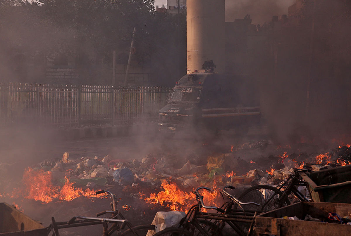 A police vehicle moves past burning debris that was set on fire by demonstrators in a riot affected area after fresh clashes erupted between people demonstrating for and against a new citizenship law in New Delhi, India, on 25 February 2020. Photo: Reuters