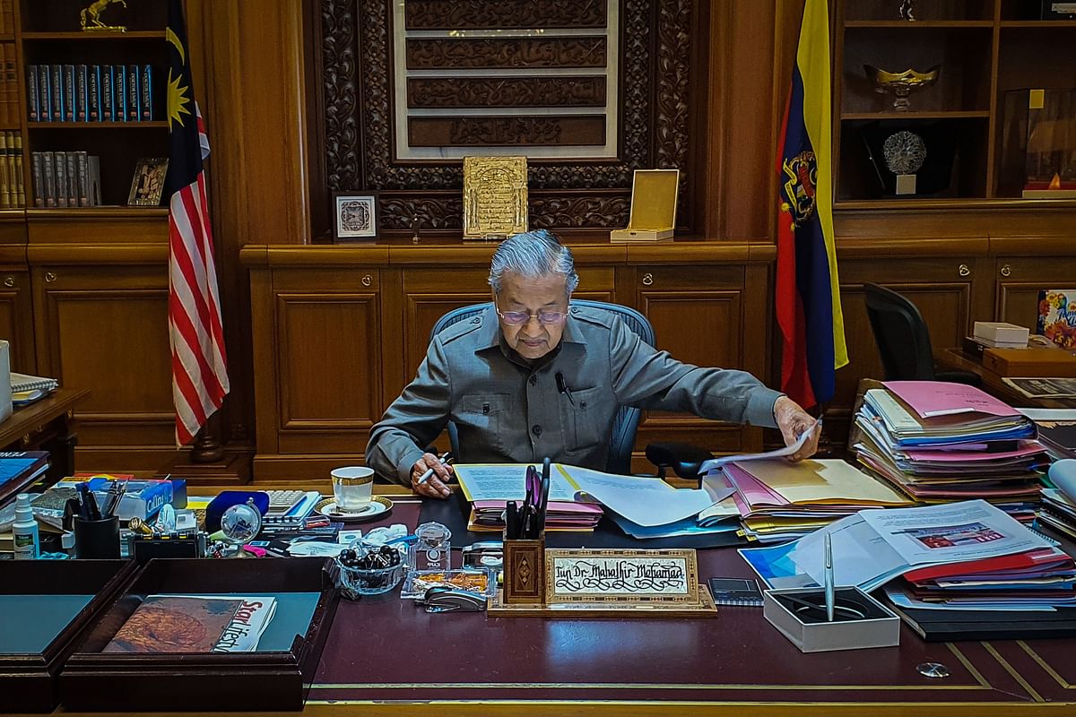 This handout photo taken and released on 25 February 2020 by the Prime Minister`s Office of Malaysia shows interim prime minister Mahathir Mohamad working in his office in Putrajaya. Photo: AFP