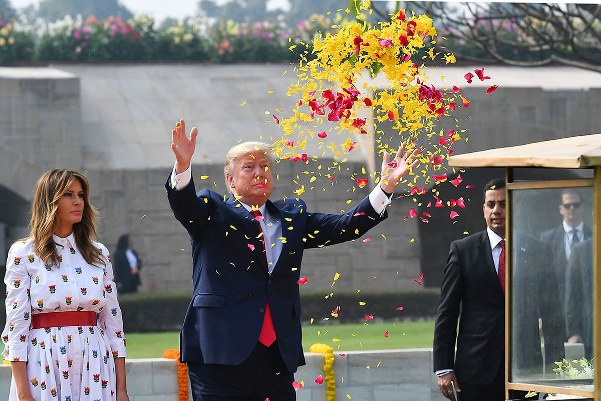 US president Donald Trump sprays flower petals as First Lady Melania Trump looks on while paying their tribute at Raj Ghat, the memorial for Indian independence icon Mahatma Gandhi, in New Delhi on 25 February 2020. Photo: AFP