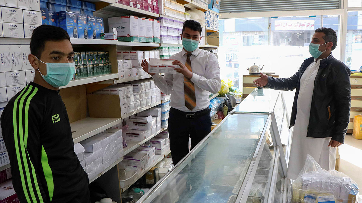 An Afghan man buys face masks in a pharmacy in Herat province. Photo: Reuters