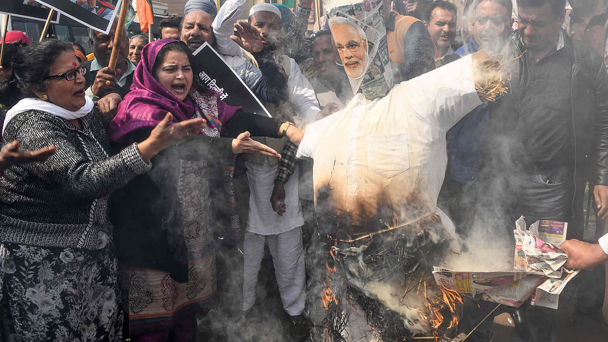 Congress Party workers shout slogans as they burn an effigy of India`s prime minister Narendra Modi (R) during a demonstration to protest against the violence occurring in New Delhi, in Amritsar on 26 February 2020. Photo: AFP