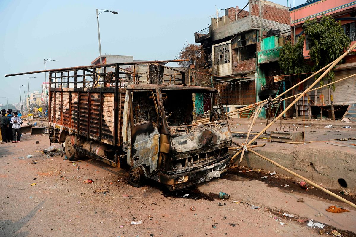 A burnt-out vehicle is pictured following clashes between people supporting and opposing a contentious amendment to India`s citizenship law, in New Delhi on 26 February 2020. Photo: AFP
