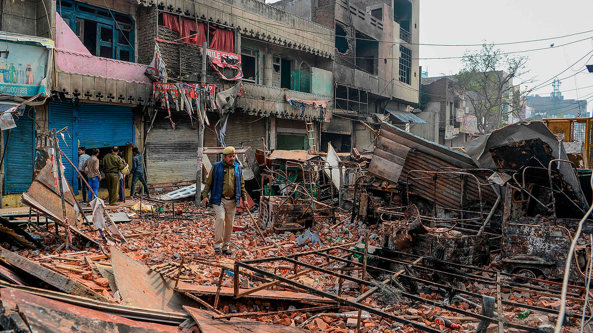 Security personnel patrol near burnt-out and damaged residential premises and shops following clashes between people supporting and opposing a contentious amendment to India`s citizenship law, in New Delhi on 26 February 2020. Photo: AFP