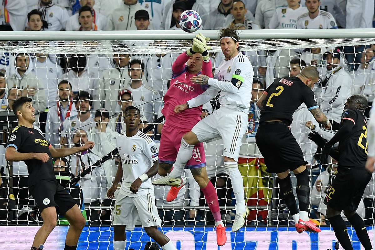 Manchester City`s Brazilian goalkeeper Ederson (C-L) stops a header by Real Madrid`s Spanish defender Sergio Ramos during the UEFA Champions League round of 16 first-leg football match between Real Madrid CF and Manchester City at the Santiago Bernabeu stadium in Madrid on 26 February 2020. Photo: AFP