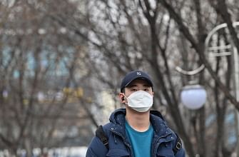 A man wearing a face mask walks along a sidewalk in Daegu on 27 February 2020. South Korea reported 334 new coronavirus cases on 27 February, taking its total to 1,595, still the largest in the world outside China, where the disease first emerged. Photo: AFP