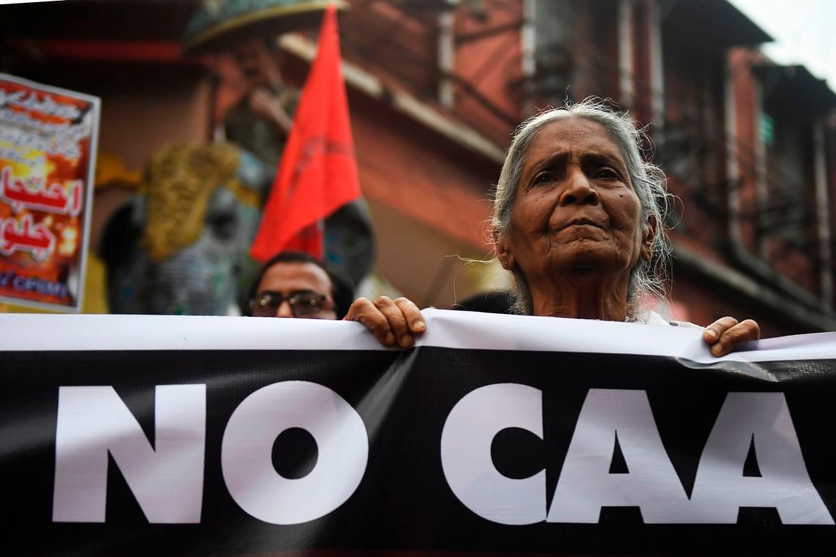 Activist of left parties stand behing a banner during a protest against India`s new citizenship in Kolkata on 26 February 2020, following clashes between people supporting and opposing a contentious amendment to India`s citizenship law in New Delhi. Photo: AFP