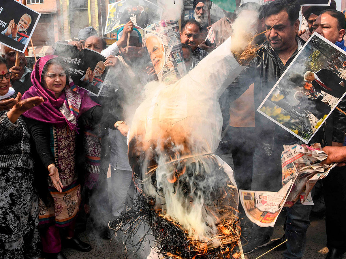 ongress Party workers shout slogans as they burn an effigy of India`s prime minister Narendra Modi (C) during a demonstration to protest against the violence occurring in New Delhi, in Amritsar on 26 February 2020. Photo: AFP