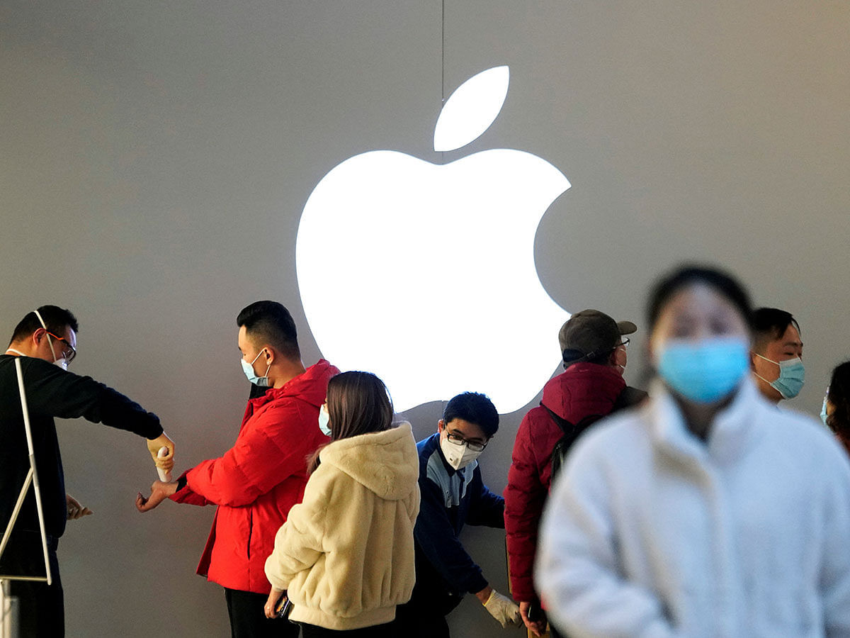 People wearing protective masks wait for checking their temperature in an Apple Store, in Shanghai. Photo: Reuters