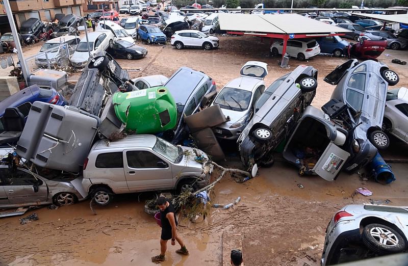 Wreckage of cars and debris are piled up in the streets of Paiporta, on 31 October, 2024, covered in mud after flash floods ravaged this area of Valencia region, eastern Spain. 