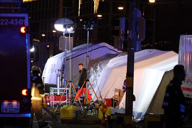 Rescuers and ambulances stand next to tents in which injured people are treated after a car crashed into a crowd at a Christmas market injuring more than 60 people on 20 December, 2024 in Magdeburg, eastern Germany